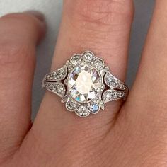 a woman's engagement ring with an old - fashioned diamond center and filigrees