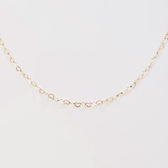 A modern necklace of interlinked hearts, beautiful and symbolic. Our Heart to Heart Necklace is delicate and modern, its chain of hearts linked side by side. It's also ideal for layering - try it paired with our Charming Link Chain Necklace or one of our Signature open heart necklaces. 14k gold-filled (no plating) or .925 sterling silver 18” adjustable heart link chain; lobster clasp can be attached to any link Models are wearing necklace as a choker, with clasp attached mid-chain Handcrafted in Chain Of Hearts, Fine Jewelry Necklace, Open Heart Necklace, Interlocking Hearts, Heart Necklaces, Modern Necklace, Heart Choker, Wear Necklaces, Heart To Heart