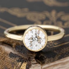 When one longs for a ring that is beautiful in its simplicity, this ring fits the bill perfectly! The diamond has a stunning faceting and faces up much whiter than its J color grade, twinkling softly with every movement of the finger. Set in a handcrafted yellow gold bezel with fine milgrain, the ring is sleek - the perfect juxtaposition between an antique diamond and a contemporary setting. Super elegant on the finger to boot! 18kt yellow gold Size 6 and fully sizable Diamond measures 6.69 - 6. Classic White Gold Jewelry With Rose Cut Diamonds, Elegant Wedding Jewelry With Smooth Bezel, Timeless White Gold Wedding Ring With Smooth Bezel, Timeless Round Rose Cut Diamond Wedding Ring, Timeless Round Wedding Ring With Rose Cut Diamonds, Timeless Wedding Ring With Rose Cut Diamonds, Classic Diamond Ring With Smooth Bezel As Gift, Timeless Rose Cut Diamond Wedding Ring, Classic Platinum Jewelry With Rose Cut Diamonds