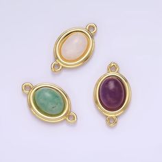 three pendants with different colored stones on them