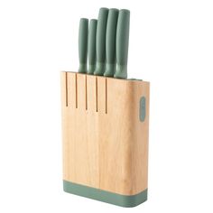 a set of knives sitting on top of a block of wood with green blades sticking out of it