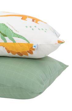 two pillows on top of each other, one green and the other white with an orange flower