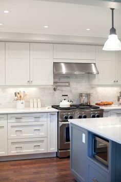 a kitchen with white cabinets and stainless steel appliances