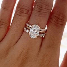 a woman's hand with two rings on it and a diamond in the middle