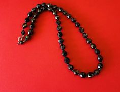 This classic nice quality 18 inch 7mm faceted jet black bead necklace is a classic closet basic. The faceted beads have seed bead spacers and wire strung smaller beads near the clasp to keep the back from being bulky. The necklace is sturdy with a gold tone lobster claw closure. The necklace is a classic inches long. This necklace is a great closet basic in wonderful vintage condition. The beads have a bright carnival sheen. I specialize in finding fun wearable vintage jewelry. Please browse my Stone Bead Necklace, Classic Closet, Black Bead Necklace, Stone Beaded Necklace, Copper Bracelet, Bright Gold, Faceted Bead, Black Beads, Jet Black