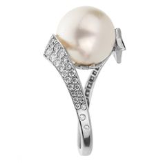 This enchanting Chanel Comète Pearl White Gold Diamond Cocktail Ring is an epitome of opulence and timeless elegance. Crafted meticulously from 18k white gold, it's a true testament to Chanel's unerring dedication to finesse and excellence in jewelry craftsmanship. The ring's unique design pays homage to Gabrielle Chanel's fascination with celestial bodies, especially comets, which is evident from the radiant shooting star motif. Encrusted with a constellation of the finest Chanel round cut diam Luxury Pearl Ring With Diamond Accents For Promise, Timeless White Gold Pearl Ring With Diamond Accents, Timeless White Gold Pearl Ring With Diamonds, Formal Diamond White Pearl Ring With Diamond Accents, Formal Pearl Ring With Diamond Accents And Cubic Zirconia, Elegant Pearl Ring With Diamond Accents For Formal Occasions, Fine Jewelry White Gold Pearl Ring With Prong Setting, Elegant Diamond White Pearl Ring With Diamond Accents, White Gold Pearl Ring With Diamond Center Stone