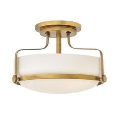 a semi flush ceiling light with a white glass shade on the bottom and gold trim