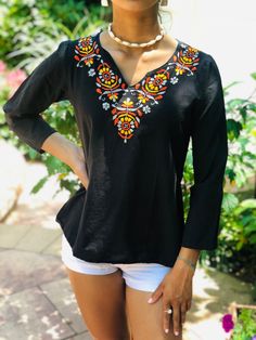 100% Cambric Black cotton top with Orange, Yellow, & Gray Embroidery.  Use As: Fashion top, Beach Cover up, Cotton Kurti, Cotton Tunic Features: A-line. Soft & breathable. Long sleeves. V-neck. Bohemian Embroidered Blouse; Retro Indian Ethnic Hippie Chic Top Care: Cold water machine wash; delicate cycle with embroidery side turned inside out. Hand wash is recommended. Should not be washed with bleach or detergents that contain bleach. Wash with like colors. Tumble dry on low heat or line dry. Ir Bohemian V-neck Top With Resham Embroidery, Traditional Embroidered V-neck Peasant Top, Casual Long Sleeve Tops With Resham Embroidery, Floral Embroidery Tunic Top For Fall, Embroidered Tunic Tops For Fall, Floral Embroidered Tunic Top For Fall, Casual Embroidered Top With Chikankari, Casual Long Sleeve Resham Embroidered Top, Casual Resham Embroidery Long Sleeve Top