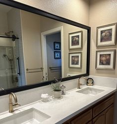 a bathroom with two sinks and a large mirror over it's sink area,