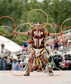 a man is doing tricks with his hands and holding two hoop rings in front of him