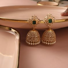 Description : Handcrafted with passion, these Sadie earrings feature CZ stones, exuding a mesmerizing sparkle. Nestled delicately at the bottom of each jhumka, the ethereal beauty of freshwater pearls adds a touch of grace and sophistication. Details & Specifications: Materials used: CZ stones with Yellow and White Gold Plating Weight - 44.03 gms Length - 6.5 cm Make it custom Want to make it custom earrings? Sure! Reach out to us at support@tarinika.com and we’ll be happy to make possible modif Gold Earrings Designs Jhumka, Jumkha Earrings Gold, Jumka Gold Designs, Small Jhumki Earrings Gold, Jhumkas Gold Indian, Gold Jhumka Earrings Bridal, Jumkas Gold, Jhumka Designs Gold, Gold Jhumka Designs