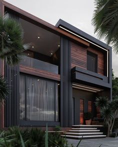 a modern house with large windows and palm trees