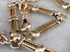 "This antique chain was originally used to hold a pocket watch, but it also makes a gorgeous choker necklace! The links are superbly crafted, with wire spirals and sleekly polished bars of 14 karat gold. This is a weighty, impressive piece and could also be worn double wrapped as a bracelet! Metal: 14K Yellow Gold Width of Chain: 7 mm Length of Chain: 13.5 Inches Marks: \"A\" Stamped on the clasp To view a video of this piece check out the link below: https://vimeo.com/579554515 SKU #: 16ZD2LNM Victorian Link Necklaces With Curb Chain, Victorian Style Necklace With Curb Chain Link, Antique Curb Chain Necklace, Victorian Style Curb Chain Link Necklace, Antique Style Oval Link Chain Necklace, Victorian Curb Chain Necklaces, Antique Curb Chain Necklace With Oval Links, Antique Formal Chain Necklaces, Victorian Necklace With Oval Link Curb Chain