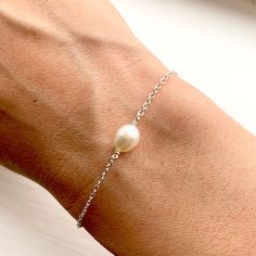 A B O U T : An elegant and dainty silver freshwater pearl chain bracelet.  Perfect for a bridesmaids gift. For a special occasion and everyday wear.  Gold variations and matching earring available. M E A S U R E M E N T S : Pearl size, 6mm long. Chain, 1.2mm thick. Length - standard 7 inches, small or large are available to choose. Please let me know if another length is required as I can make any length. M A T E R I A L S : Freshwater pearl and sterling silver. All materials sourced locally. P Dainty Sterling Silver Pearl Bracelet, Dainty Pearl Bracelet With Pendant As Gift, Dainty Sterling Silver Pearl Bracelet With Charm, Delicate Pearl Pendant Bracelet As Gift, Dainty Sterling Silver Pearl Drop Bracelet, Silver Pearl Bracelet With Pearl Drop For Gift, Silver Pearl Bracelet With Pearl Drop As Gift, Silver Pearl Drop Bracelet As Gift, Sterling Silver Pearl Bracelet As Gift