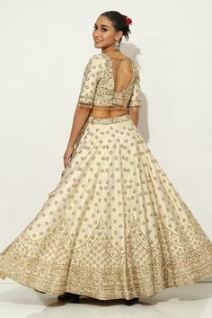 Ivory and gold kalidar lehenga with all over Padma bagh motif embroidery using zardozi highlights and tassel ornamentation. Paired with an elbow sleeves floral jaal embroidered leaf neck blouse with dangling glass beads hem and a bloom border embroidered dupatta. - Aza Fashions Elegant Raw Silk Lehenga With Gota Work, Elegant Lehenga With Gota Work In Raw Silk, Elegant Navratri Choli With Gota Work, Elegant Gota Work Choli For Navratri, Elegant Choli With Gota Work For Diwali, Elegant Gota Work Choli For Diwali, Festive Off White Choli With Resham Embroidery, Festive Off-white Choli With Resham Embroidery, Elegant Off-white Lehenga For Festive Occasions