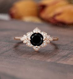 a black and white diamond ring sitting on top of a wooden table