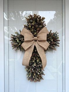 a wreath with a bow hanging on the front door