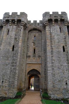 the entrance to an old castle with a walkway leading up to it's gates