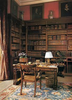 an old library filled with lots of wooden bookshelves and desk covered in papers