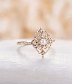 a close up view of a ring with pearls on the front and back, sitting on a white surface