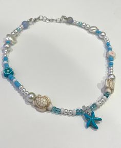 this necklace is so cute with blue accents and white details! cute charms paired with pearls and seed beads with a starfish in the middle! Sea Necklace, Canoga Park, Brown Mushroom, White Details, Sea Theme, Cute Charms, Blue Accents, How To Make Beads, Chain Styles