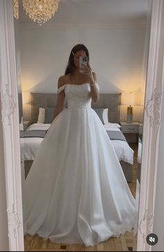 a woman taking a selfie in her wedding dress while standing in front of a mirror