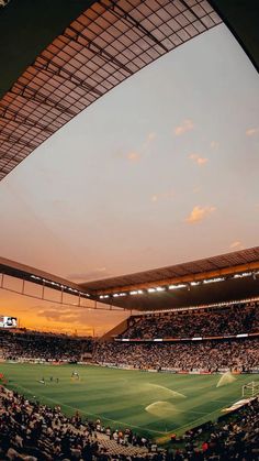 an empty soccer stadium at sunset with the sun going down