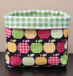 an apple print fabric storage bag sitting on top of a table