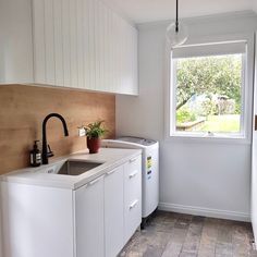 a kitchen with a sink, washer and dryer next to a large window