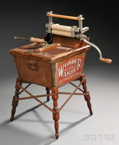 an old fashioned wooden washer machine with two tools on it's back legs