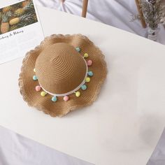 a straw hat with beads on it sitting on top of a table next to a magazine