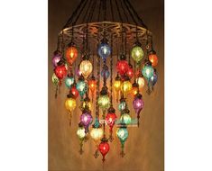 a chandelier with many colorful lights hanging from it's sides and on the ceiling