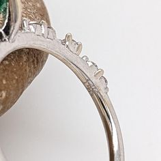 This minimalist 14K white gold setting features an earth-mined emerald with natural earth-mined diamonds. A delicate ring design perfect for an eye-catching engagement or anniversary. This ring also makes a beautiful May birthstone gift for your loved ones! The occasions to show off this ring are endless - mother's Day, graduation, wedding, birthday, date night, Christmas, etc. :) This ring is made with solid 14K Gold and naturally Earth-mined SI / G-H diamonds. Diamond Ring With Prong Setting For May Birthstone, Emerald Ring With Prong Setting In Round Cut, Emerald Rings With Diamond White Halo Setting, Emerald Rings With Prong Setting And Round Cut, Emerald Ring With Prong Setting And Round Cut, Emerald Ring With Center Stone In 14k White Gold, Green Diamond Half Eternity Round Cut Ring, Green Diamond Ring With Round Band, Diamond Promise Ring With Prong Setting For May Birthstone