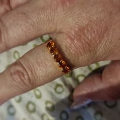 a close up of a person's hand with a gold ring on their finger