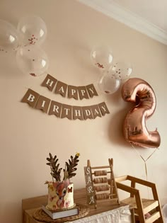 a birthday party with balloons and decorations on the wall