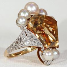 "I wanted something fun, something fresh, something subtle. Then I saw this pearly citrine crown ring and decided that \"subtle\" was no longer in my vocabulary. This piece is an assemblage of beauty, a collection of gems fit for a king. Honestly, I have no regrets. This regal ring features a large calf cut citrine stone topped with a crown of beautiful white pearls accented with diamonds. The stones in this ring are set in platinum with an 18 karat gold back and shank. The lively citrine is a v Elegant Citrine Ring Jewelry, Elegant Open Citrine Ring, Elegant Citrine Open Ring, Elegant Open Ring Citrine Rings, Elegant Open Ring With Citrine, Elegant Topaz Ring For Anniversary, Elegant Multi-stone Citrine Topaz Ring, Elegant Multi-stone Topaz And Citrine Ring, Elegant Pear-shaped Topaz Jewelry