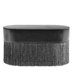 a black ottoman with fringe trim on it