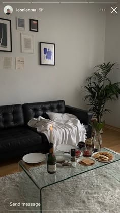 a living room with a couch, coffee table and pictures on the wall