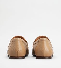 Loafers in fine exposed grain leather, with leather outsole. A sober and timeless taste style, combined with the elegant metal double T accessory. Luxury Beige Leather Moccasins, Luxury Beige Leather Shoes With Textured Sole, Elegant Beige Leather Moccasins, Timeless Leather Shoes With Textured Sole For Work, Business Leather Loafers With Textured Detail, Elegant Beige Loafers With Leather Lining, Beige Calf Leather Loafers With Leather Sole, Calf Leather Moccasins With Almond Toe For Galas, Classic Flats With Leather Sole For Galas