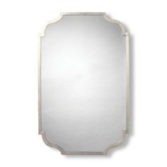 a large silver mirror on a white wall