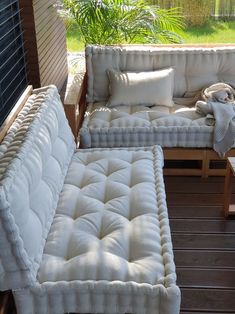 a white couch and chair on a wooden deck