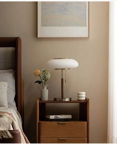 a bedroom with a bed, nightstand and painting on the wall