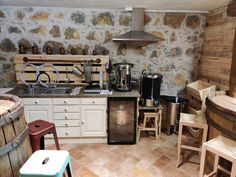 a kitchen filled with lots of appliances and wooden barrels next to a stove top oven