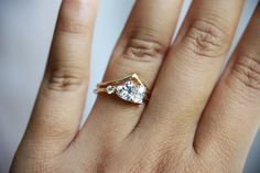 a woman's hand with a diamond ring on top of her finger, showing the center stone