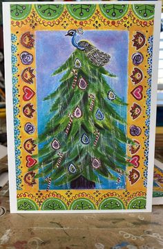 a card with a peacock sitting on top of a christmas tree