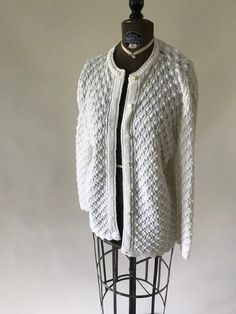 a white knitted cardigan sweater on a mannequin headdress,