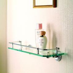 a bathroom shelf with two bottles on it and a mirror in the corner behind it