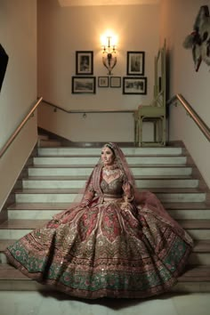 a woman in a wedding dress sitting on some stairs