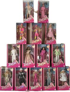 barbie dolls are stacked up in pink and white boxes with the names barbie on them