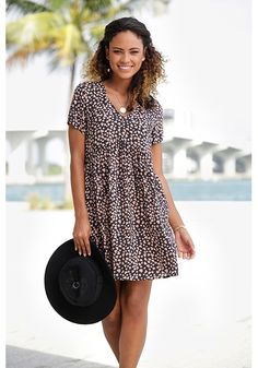 This casual dress with a loose fit and cute print is perfect for a fun day out. Casual Printed V-neck Mini Dress, Printed Relaxed Fit Dresses For Day Out, Relaxed Fit Printed Dress For Day Out, Casual Mini Length Printed Dress, Casual V-neck Mini Dress For Daytime, Casual Printed Mini Dress For Spring, Casual Knee-length Mini Dress For Daytime, Casual V-neck Daytime Dress, Trendy Black Mini Dress For Vacation